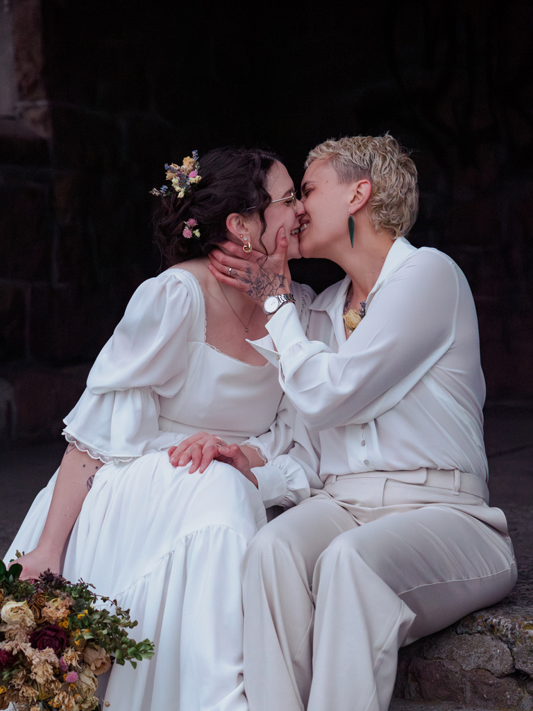 a lesbian couple smiles as they lean in for a kiss at their elopement in Ōtautahi Christchurch